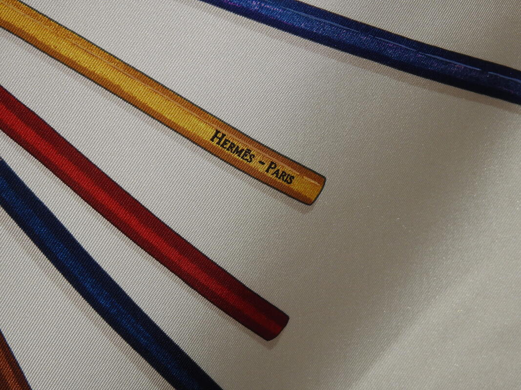 Close up picture of the Hermes brand appearing in a used Hermes scarf A Vos Crayons